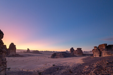 Dramatic sunset-to-sunrise timelapse in the rocky desert landscape of Saudi Arabia, showcasing unique sandstone formations, shifting light, and vibrant sky transitions.