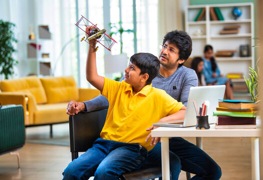 Indian schoolboy and father exploring aeronautical engineering concepts together using a laptop