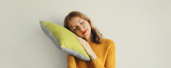 Healthy sleep, happy relaxed sleepy young woman lying on soft comfortable pillow imagining a bed