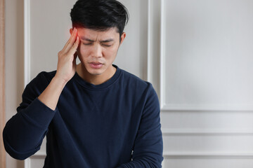 close up young asian man frowned with stressful and use hand massage on head to relief headache ...