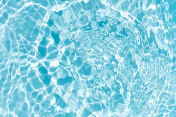 Obraz premium Blue water with ripples on the surface. Defocus blurred transparent blue colored clear calm water surface texture with splashes and bubbles. Water waves with shining pattern texture background.