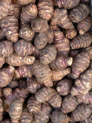 Closeup of fresh raw Jerusalem artichoke (Helianthus tuberosus) tubers on a stall at a farmers market