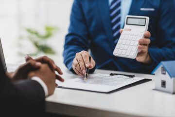 Businessman, real estate agents discuss house sale prices, fee, mortgage, interest, rent, cash flow, loan. Businessman is offering a house price to a customer.