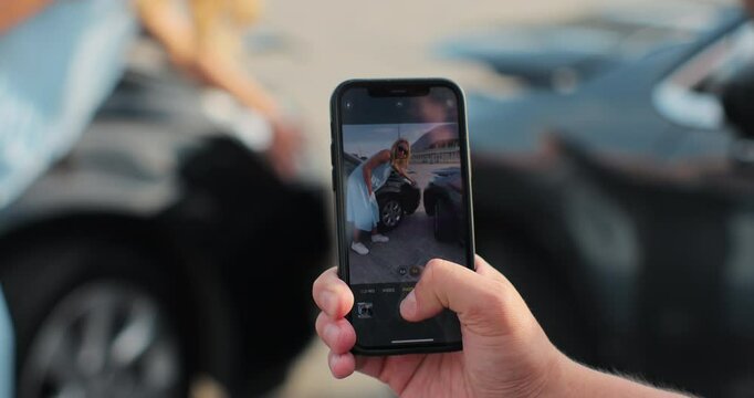 Man taking photo of damaged car on mobile phone. Road safety and insurance concept.