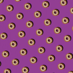 Pattern with choclate donuts with Christmas tree on top on the violet background. Concept of New Year, Celebration, Cafe. Food background