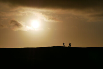 Fototapeta premium People watching a colorful sunset at a Maspalomas dune, Gran Canaria island