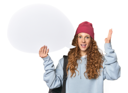 Redhead holding a comic speech bubble receiving a pleasant surprise, excited and raising hands.