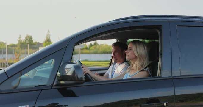 Man driving instructor sitting on passenger seat in car and showing way to female student in driving school. Driver courses, exam and people concept.