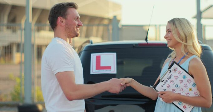 Instructor and happy man with driving license outdoors. Driver courses, exam and people concept.