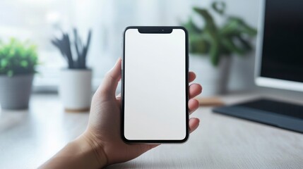 Holding Smartphone with Blank Screen in Hand at Workspace Setting