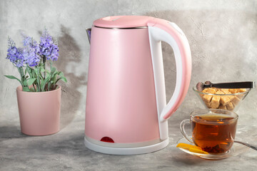 Teapot with metal strainer inside. Kitchen utensils on gray background.