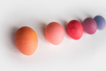 Easter eggs in purple and pink shades are lying on a white background with a shadow photo