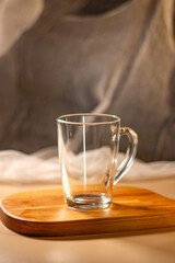 Empty transparent cup on wooden tray. Mock up for design. Served table. Preparation for making drink