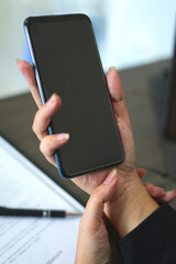 An asian tired business woman working for a long time and typing the computer, and using the mobile phone, so her wrist is hurt and she is massaging her hurt wrist by another hand, an office syndrome.