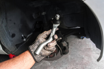 Obraz premium Mechanic holding tie rod end or steering component for car repair