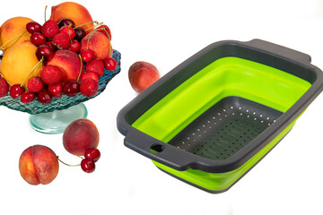 Silicone colander for washing fruits and vegetables on a white background.