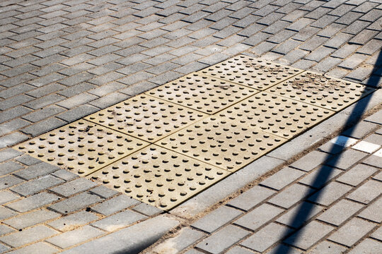 The manhole cover is located prominently on the paved surface of the city street