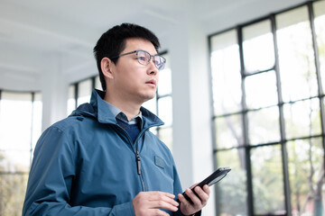 Fototapeta premium asian businessman using smart phone in modern office