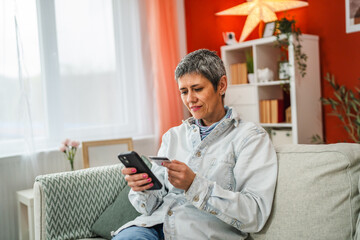 mature woman use mobile phone and credit card for online shopping