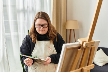 Young woman with Down syndrome creates art at home in a cozy and inviting atmosphere