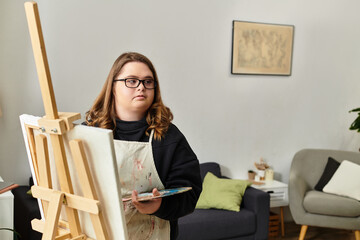 Young woman proudly creating art in her cozy home space showcasing her creativity and confidence