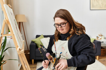 Creative young woman with Down syndrome enjoys painting in her cozy home environment