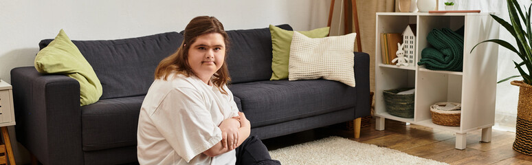 Obraz premium Embracing confidence and comfort in a cozy home setting with a young woman who has Down syndrome