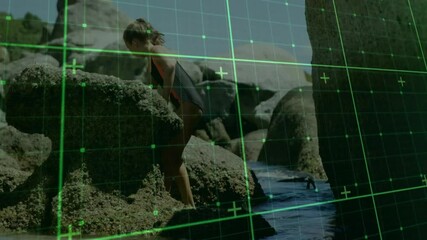 Exploring rocky shore, child interacting with digital grid overlay animation - Powered by Adobe