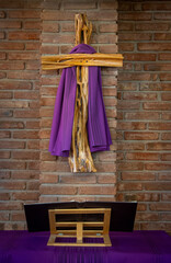 A sermon book and cross draped in purple for observance of Lent