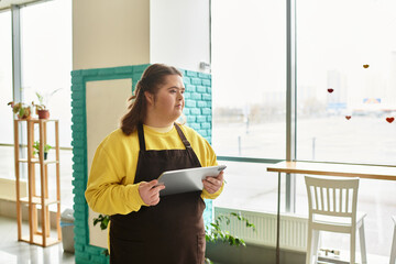 Young woman with Down syndrome confidently managing tasks in a cozy cafe setting