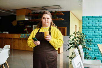 Young woman confidently enjoys a drink in a trendy cafe setting while wearing casual attire