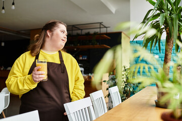 Young woman with Down syndrome enjoys a drink in a cozy cafe filled with greenery