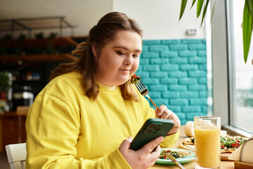 Young woman enjoys casual meal in a cozy cafe while scrolling on her phone