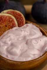 wooden bowl with fresh yogurt with ripe fresh figs