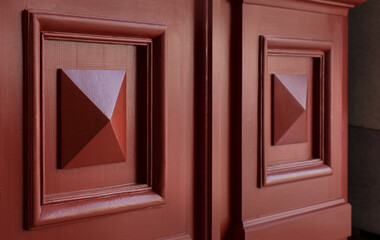 Fragment of a door with a carved rhombus. The rich color emphasizes the architectural details of...