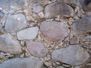 This is a closeup view of a rustic stone wall that prominently features various textures and colors throughout