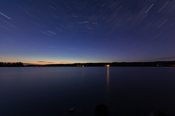 Star on the night sky by a lake in Finland in early summer