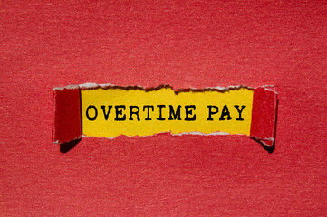 Overtime pay message written on ripped torn red paper on yellow background. Conceptual overtime pay...