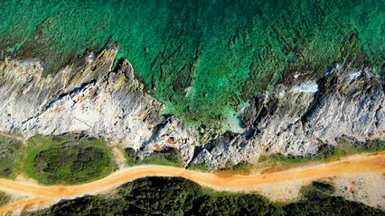 This stunning aerial photo captures the picturesque coastline near Medulin, Istria with crystal-clear turquoise waters, rocky shores, and dense forests. Trail 333 in Ližnjan runs along this coast