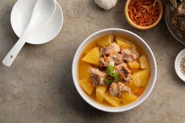 Pork Baby Back Ribs or pork cartilage clear soup with pineapple fruit in white bowl.sweet and sour test,asian food.Top view copy space.