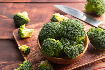 sliced broccoli in wooden bowl on the table,edible green plant in the cabbage family,whose large...