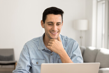 Man sits at desk with laptop working from homeoffice, read emails, responding to messages,...