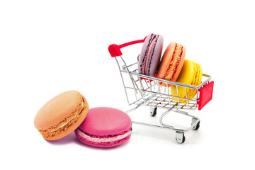 Shopping supermarket cart with colorful varied assortment macarons cookies isolated on a white...