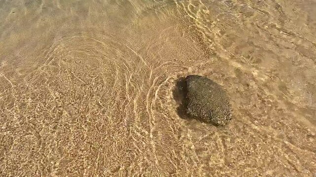 Golden sand and stone, splashing waves and clean, clear waters of Tigania beach, Sithonia, Greece 