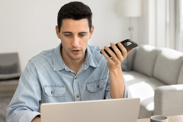 Man lead conversation using speakerphone, engaged in formal communication on smartphone,...