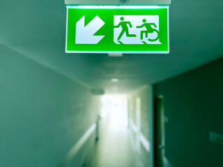 emergency exit sign, Emergency exit sign with wheelchair accessibility symbol in a modern building corridor. Safety evacuation route for people with disabilities