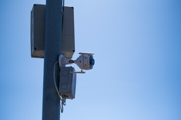 CCTV camera on pole with blue sky background, security concept.