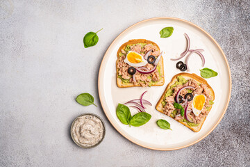 Tuna toast. Open sandwiches with whole grain bread, canned tuna, onion and boiled egg. Top view