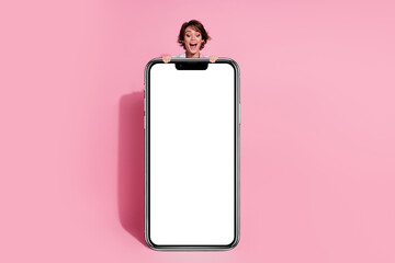 Full body portrait of nice young woman empty space smart phone display isolated on pink color background