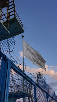 the national modern flag of Afghanistan behind a metal fence and barbed wire